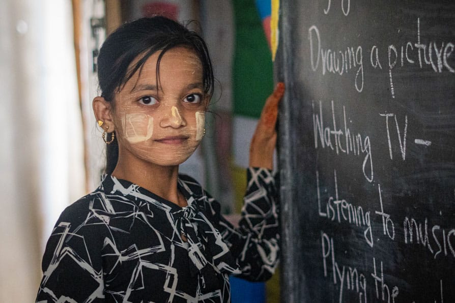 A girl writes on a blackboard at a learning center in Kutupalong Refugee Camp, Bangladesh.