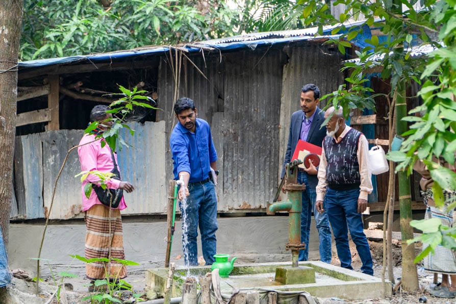 A group of men inspect a tap that forms part of a newly-installed safe water network in Kalishakhali village, Bangladesh.