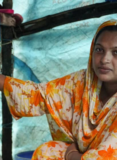 A woman fills a metal pitcher from a tap in her home that forms part of a safe water network in Kalishakhali village, Bangladesh.
