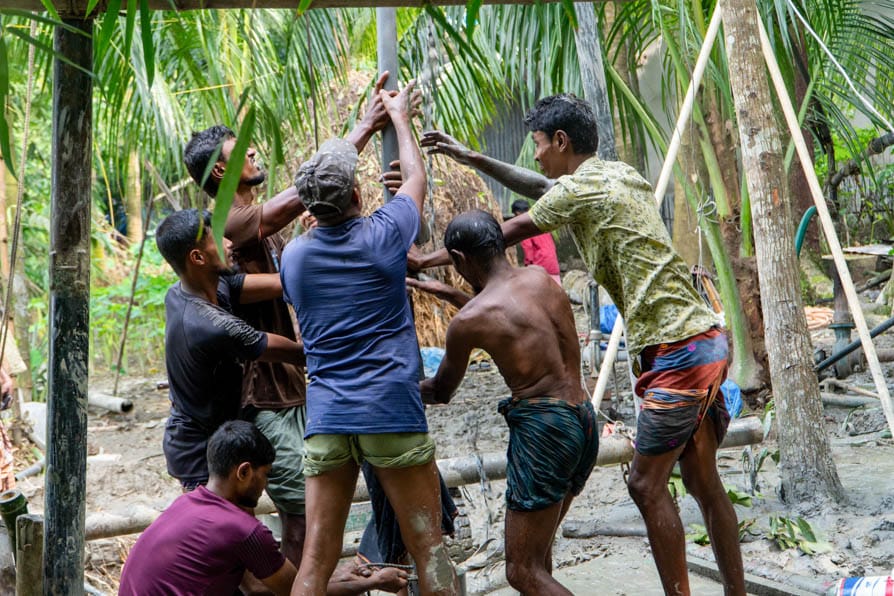 A group of men work together to dig a deep tube well that forms part of a safe water network in Kalishakhali village, Bangladesh.