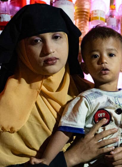 A Rohingya mother sits holding her young son in the family's shelter in Kutupalong Refugee Camp in Bangladesh.