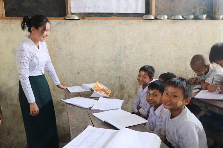 A teacher and children share a happy moment in class at a school in southeastern Myanmar.