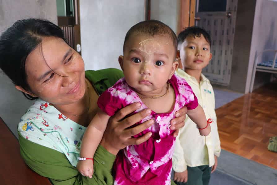 A woman holds a baby in a maternity waiting home in southeastern Myanmar.
