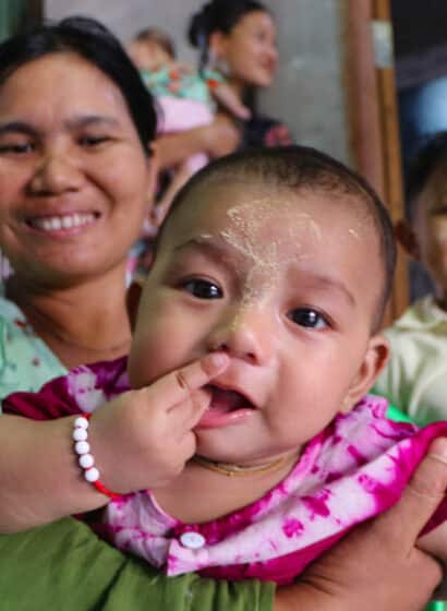 A baby girl is held in her mother's arms in a maternity waiting home in Myanmar
