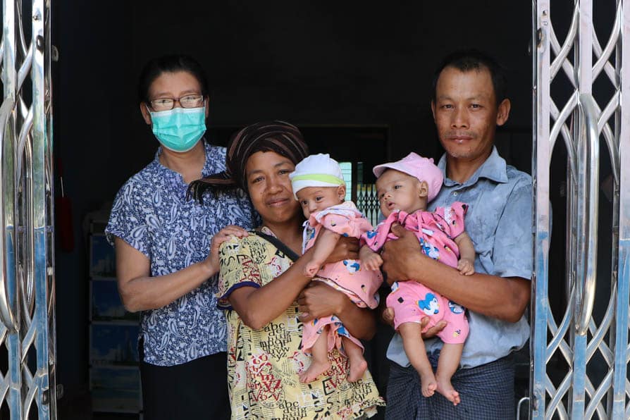A couple stand with their twin babies accompanied by a nurse at a maternity waiting home in southeaster Myanmar.