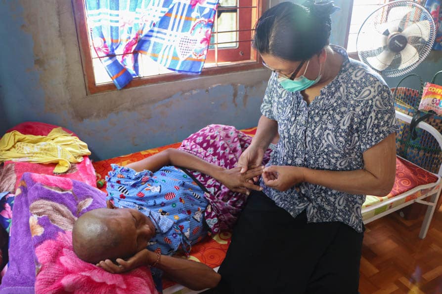 A nurse sits with a pregnant woman at a maternity waiting home in southeastern Myanmar
