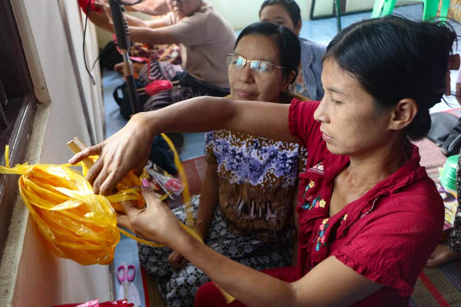A woman learns how to weave using plastic twine at a safe space for women and girls in southeastern Myanmar.