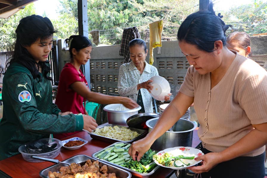 Women serve themselves food at a safe space for women and girls in southeastern Myanmar.