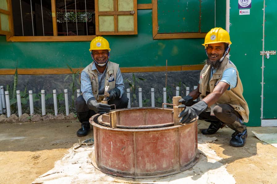 Rohingya WASH workers use a steel mould to produce concrete cesspit rings in Kutupalong Refugee Camp, Bangladesh.