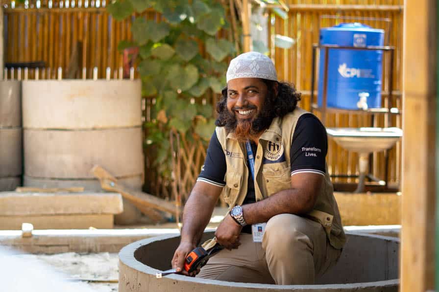 A WASH engineer measures a concrete ring used in cesspit construction in Kutupalong Refugee Camp, Bangladesh.