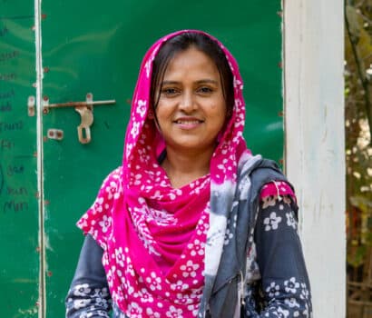 Naznin, a hygiene promotion officer, stands in front of a toilet block that incorporates a menstrual hygiene management chamber in Kutupalong Refugee Camp, Bangladesh.