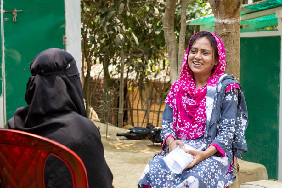 Naznin, a hygiene promotion officer, talks to a Rohingya woman in Kutupalong Refugee Camp, Bangaldesh.