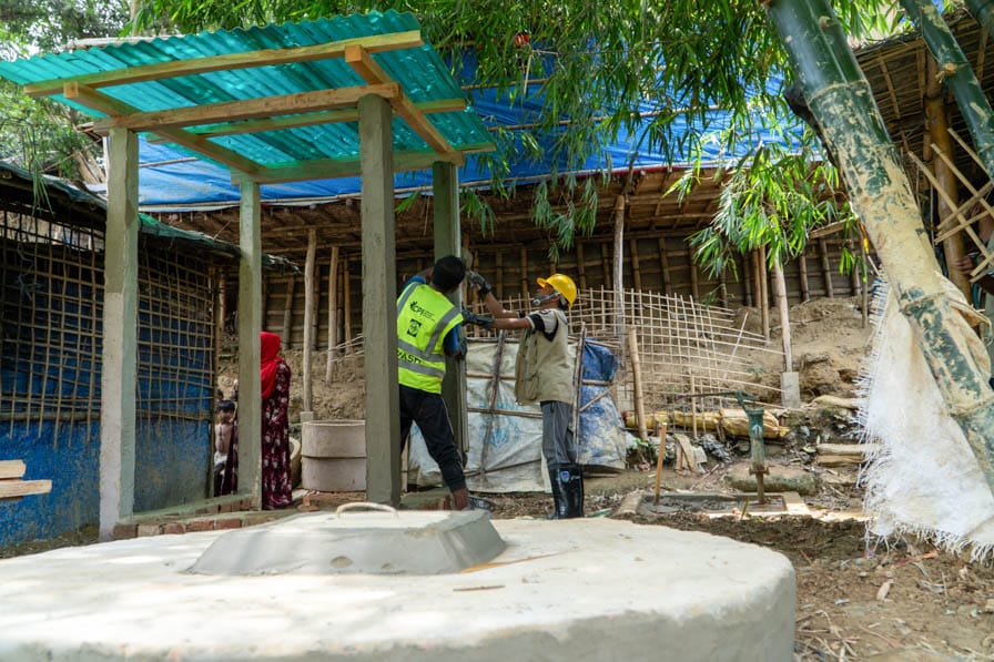 Rohingya WASH workers build concrete pillars in Kutupalong Refugee Camp, Bangladesh.