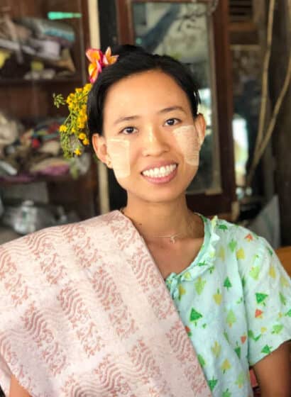 A handloom weaver with woven fabric over her shoulder in Amarapura, Myanmar.