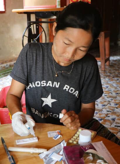 A community volunteer conducts a malaria rapid test in southeastern Myanmar.