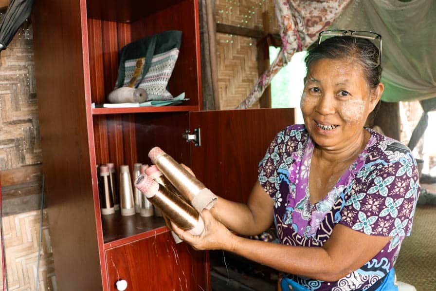 Daw Tin Tin Yee holds spools of yarn at her home in Amarapura, Myanmar.