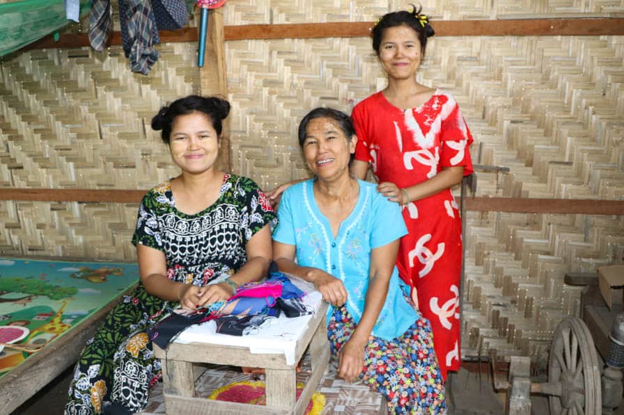 Handloom weaver, Khin Myo Wai, flanked by her two daughters in Amarapura, Myanmar.
