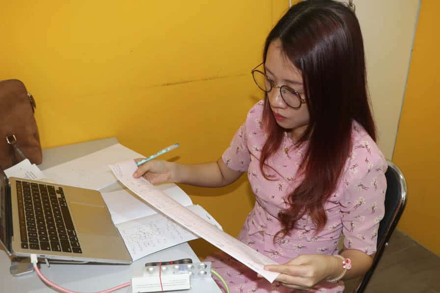 A health worker studies ECG results at Nae Thit Kyan Mar's clinic in Amarapura, Myanmar.