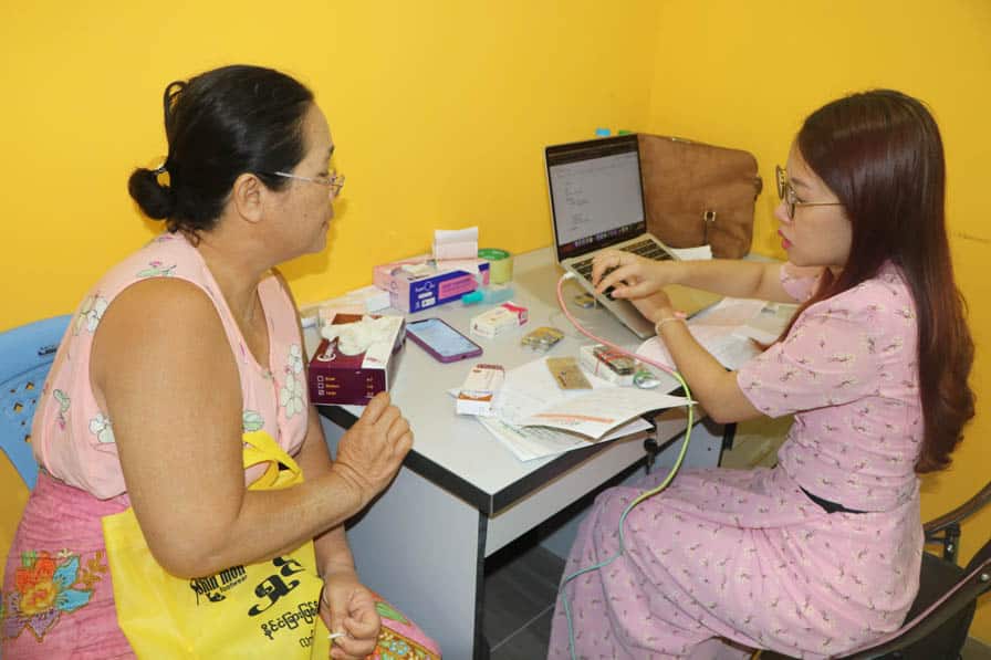 A health care worker conducts a patient check-up at Nae Thit Kyan Mar's clinic in Amarapura, Myanmar.