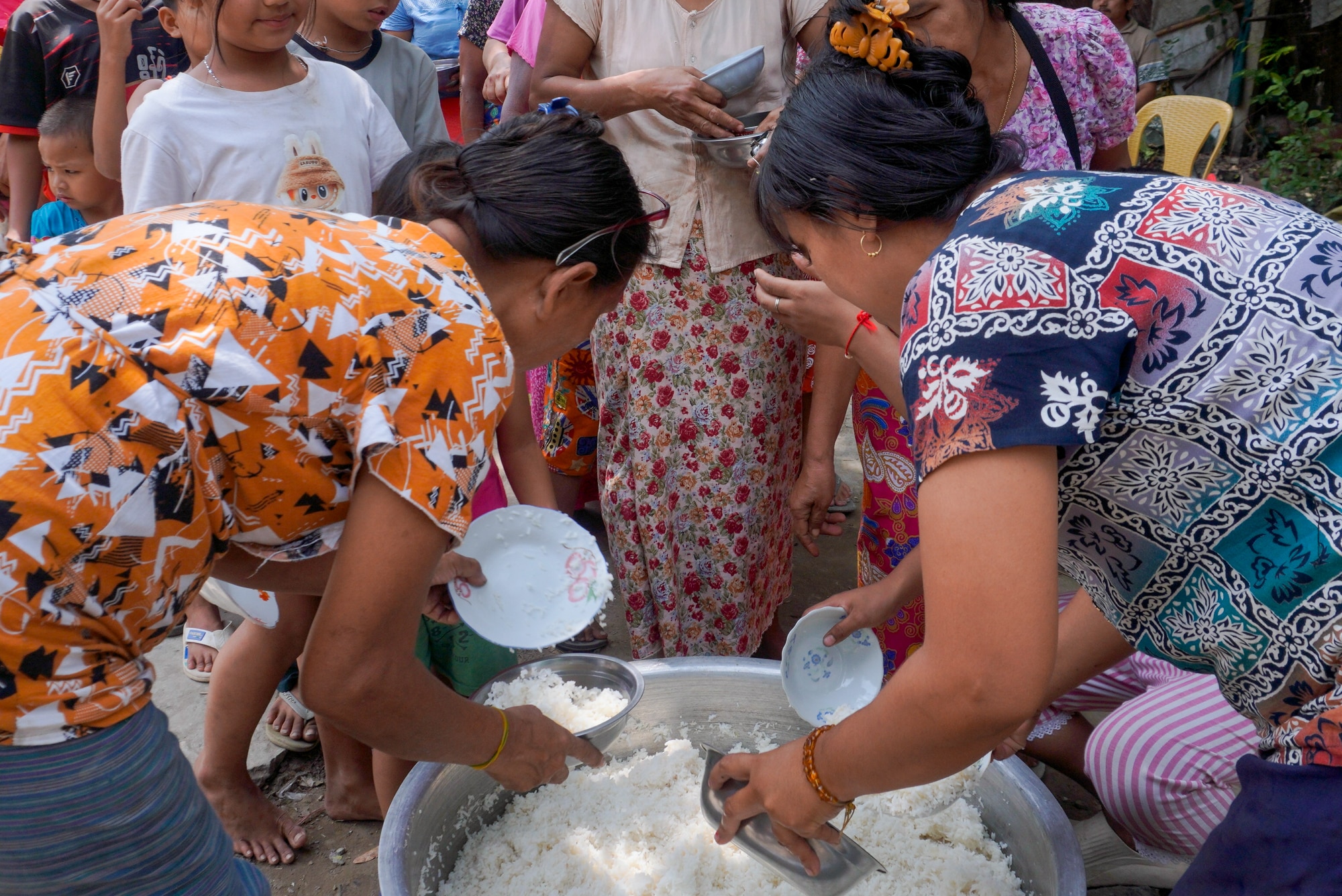 Survivors of the March 2025 earthquake receive rice at a field kitchen in Mandalay, Myanmar, set up in the aftermath of the March 2025 earthquake.
